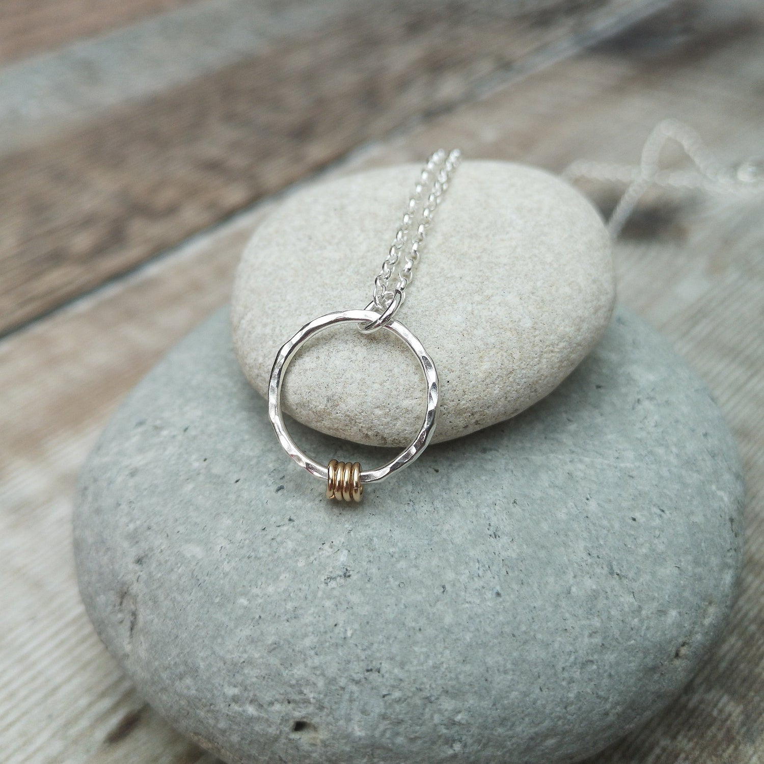 40th birthday necklace displayed on a stack of grey stones. 