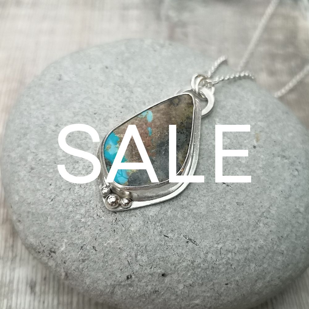 Image of turquoise necklace with the word SALE above it. 