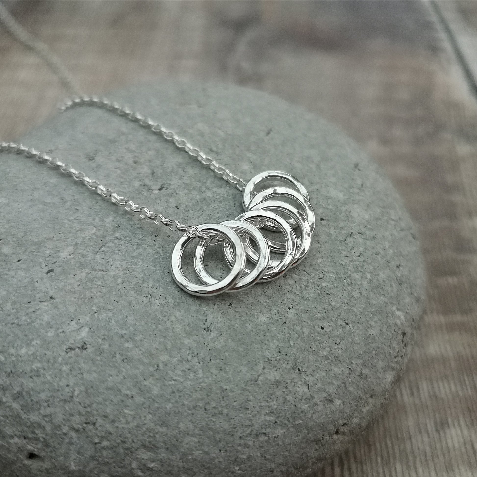 Six small Sterling Silver open circles with hammered texture finish on a silver chain.