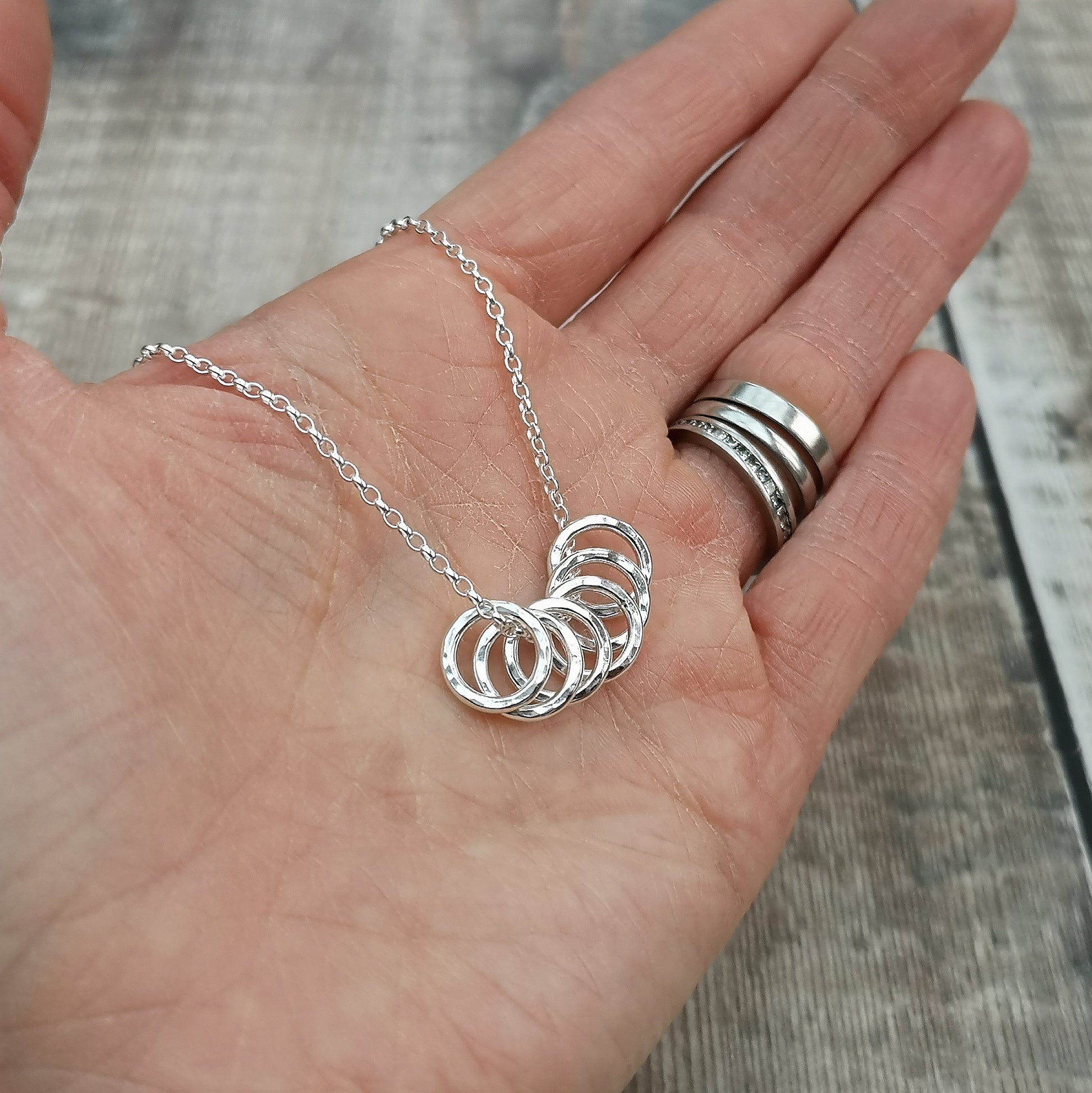 Six small Sterling Silver open circles with hammered texture finish on a silver chain.