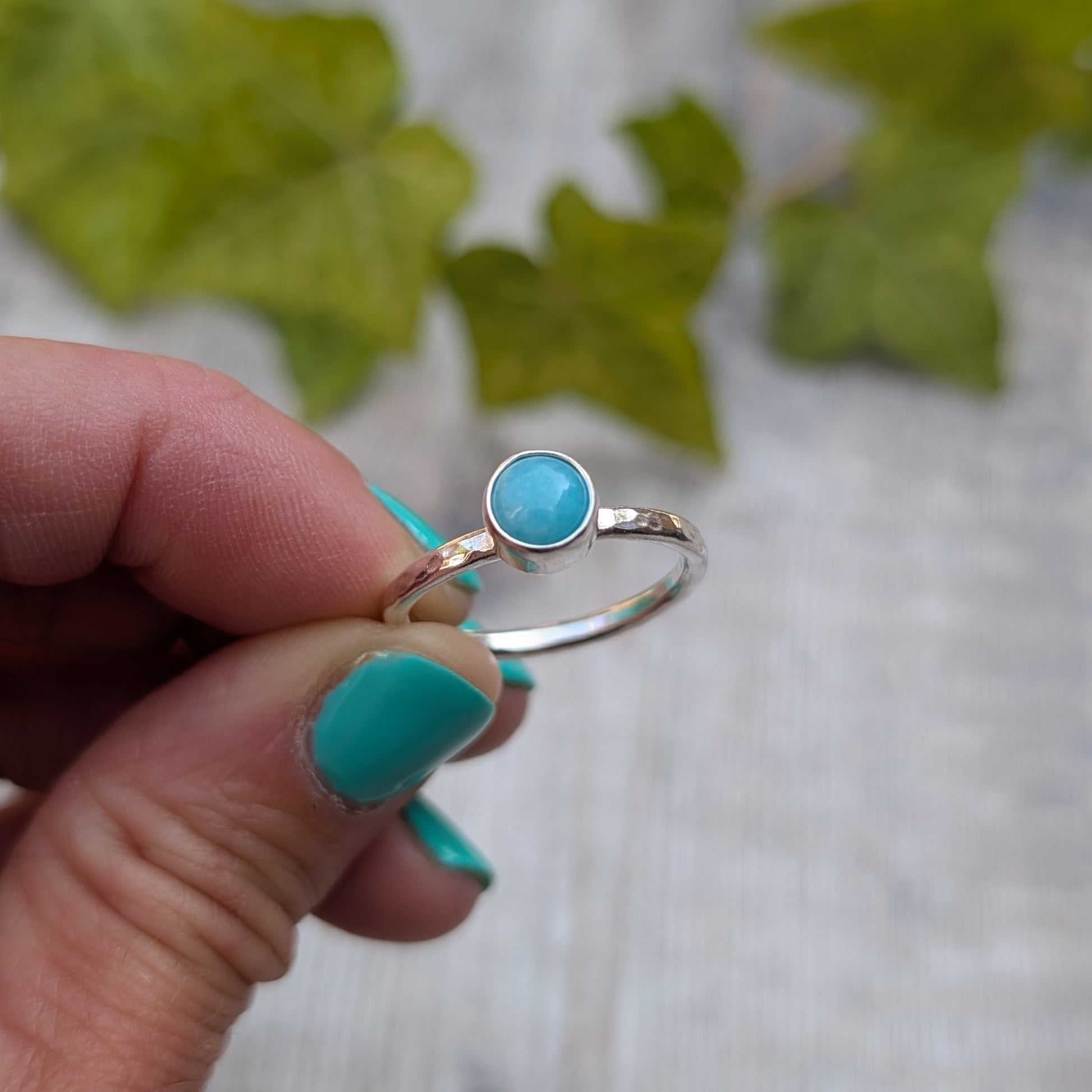 Close up of amazonite ring size R held between fingers, showing the handmade recycled Sterling Silver band with a polished round Amazonite gemstone.