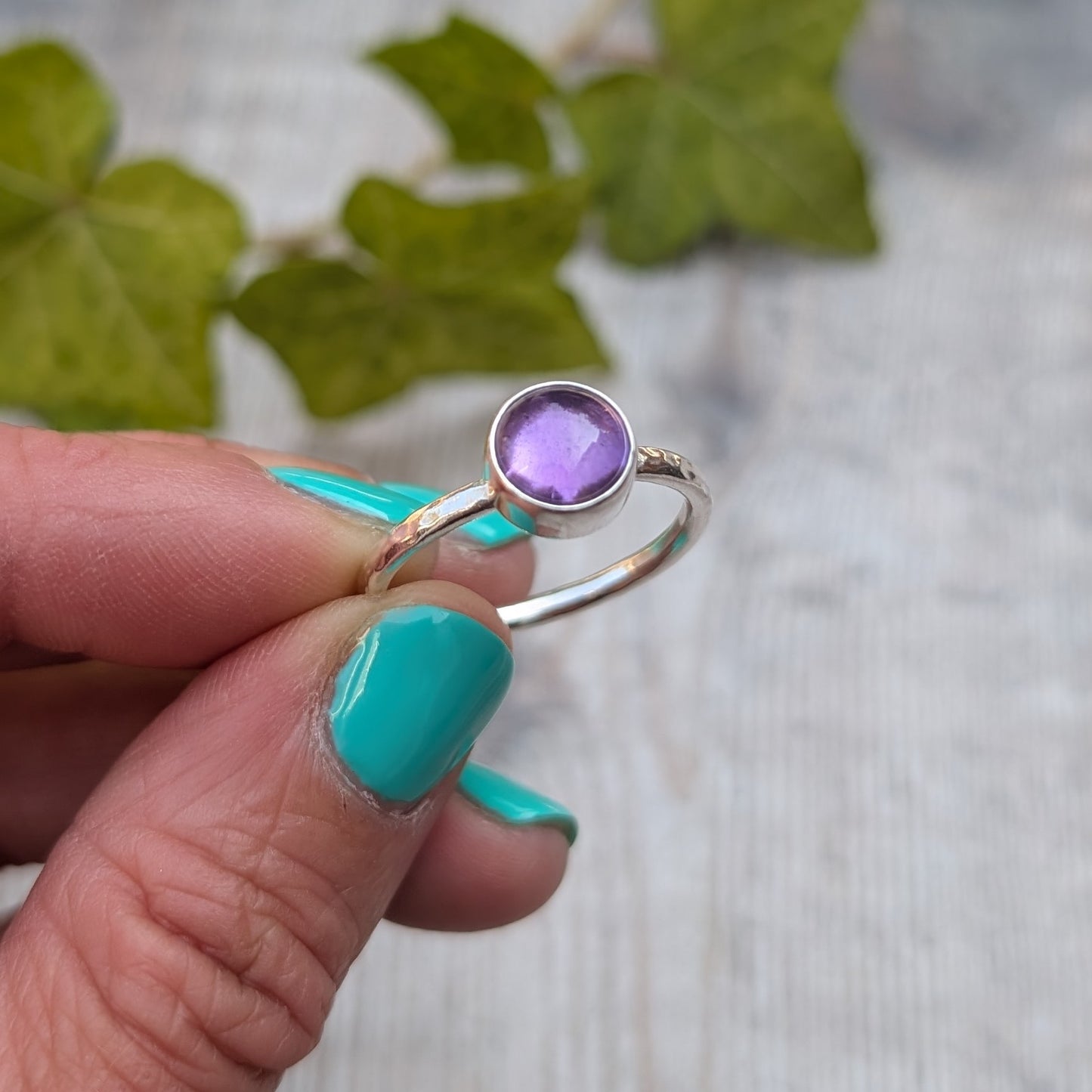 Amethyst ring size S handmade from recycled Sterling Silver, close up of the polished silver band and round purple Amethyst gemstone.