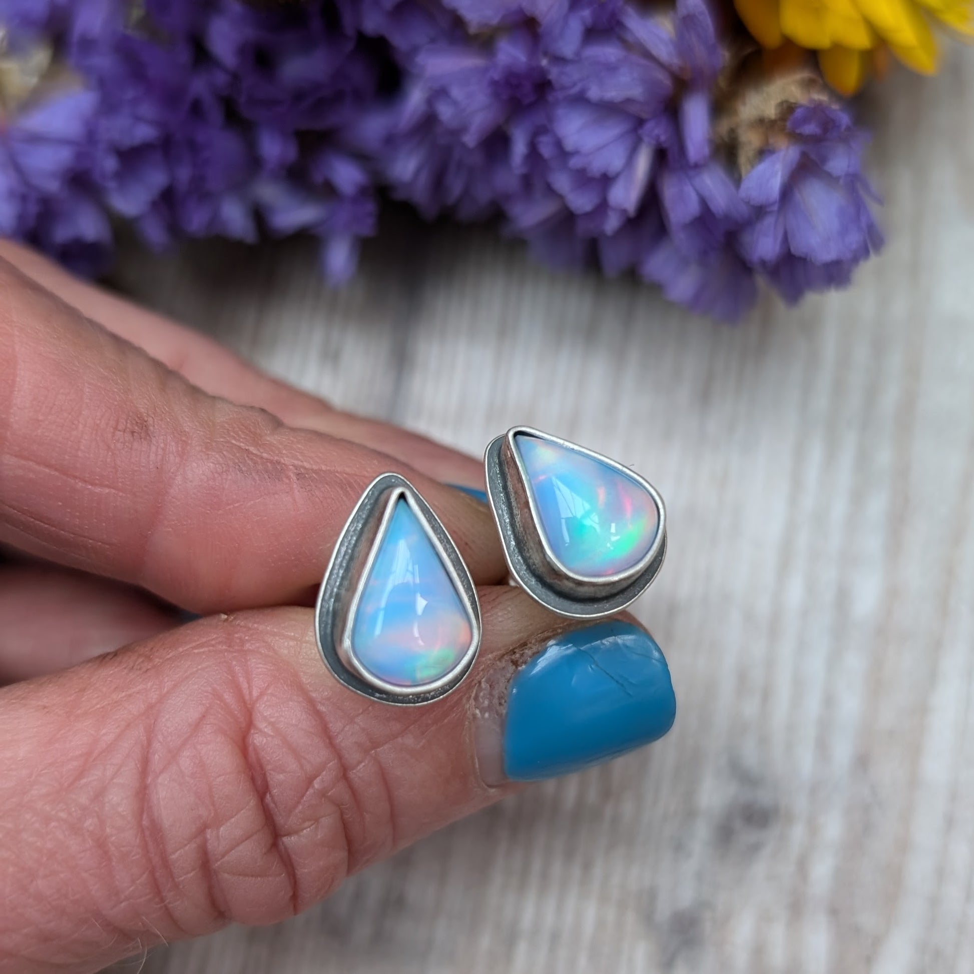 Teardrop shaped Aurora Opal with iridescent rainbow hues and smooth finish, set in simple oxidised silver bezel attached to stud bar.