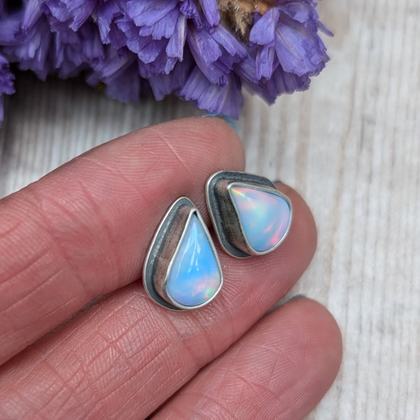 Teardrop shaped Aurora Opal with iridescent rainbow hues and smooth finish, set in simple oxidised silver bezel attached to stud bar.