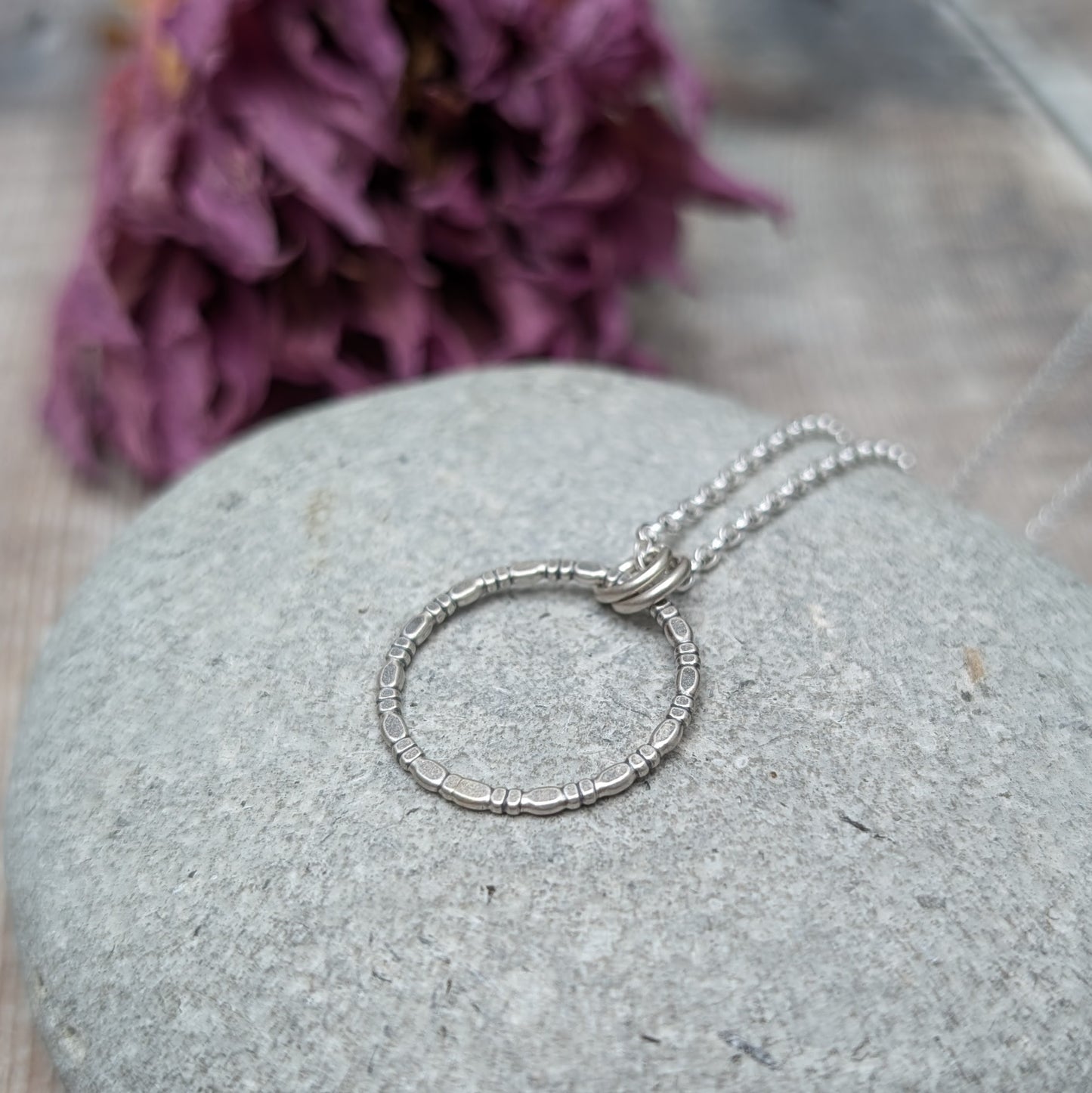 Pendant is Sterling Silver open circle made of beaded repeating pattern, suspended from silver chain via two small open circle links.