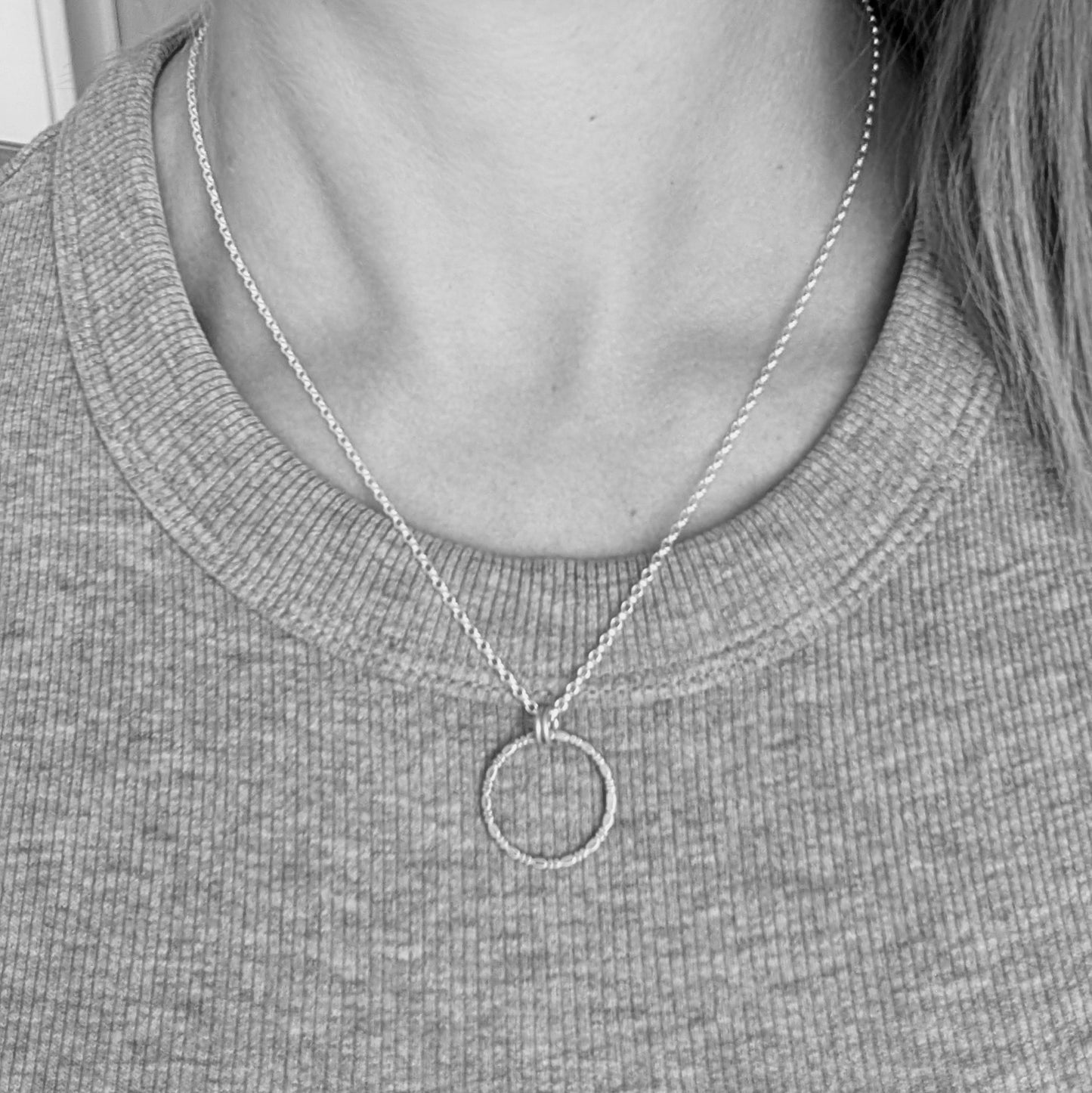 Pendant is Sterling Silver open circle made of beaded repeating pattern, suspended from silver chain via two small open circle links.