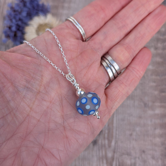 Blue Spotty Lampwork Glass Necklace shown in the palm of a hand to show size and detail.