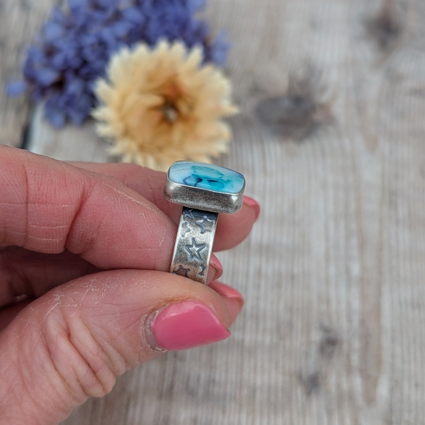 Side view of Blue Surfite Rectangle Ring with Silver Star Stamped Band showing the thickness of the silver setting and star detail on the band.