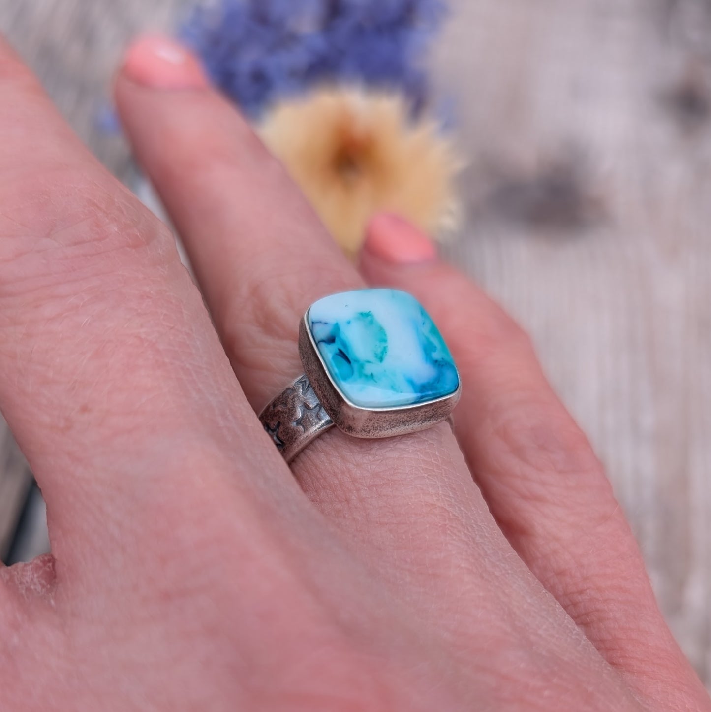 Blue Surfite Rectangle Ring with Silver Star Stamped Band worn on a hand showing scale and fit.