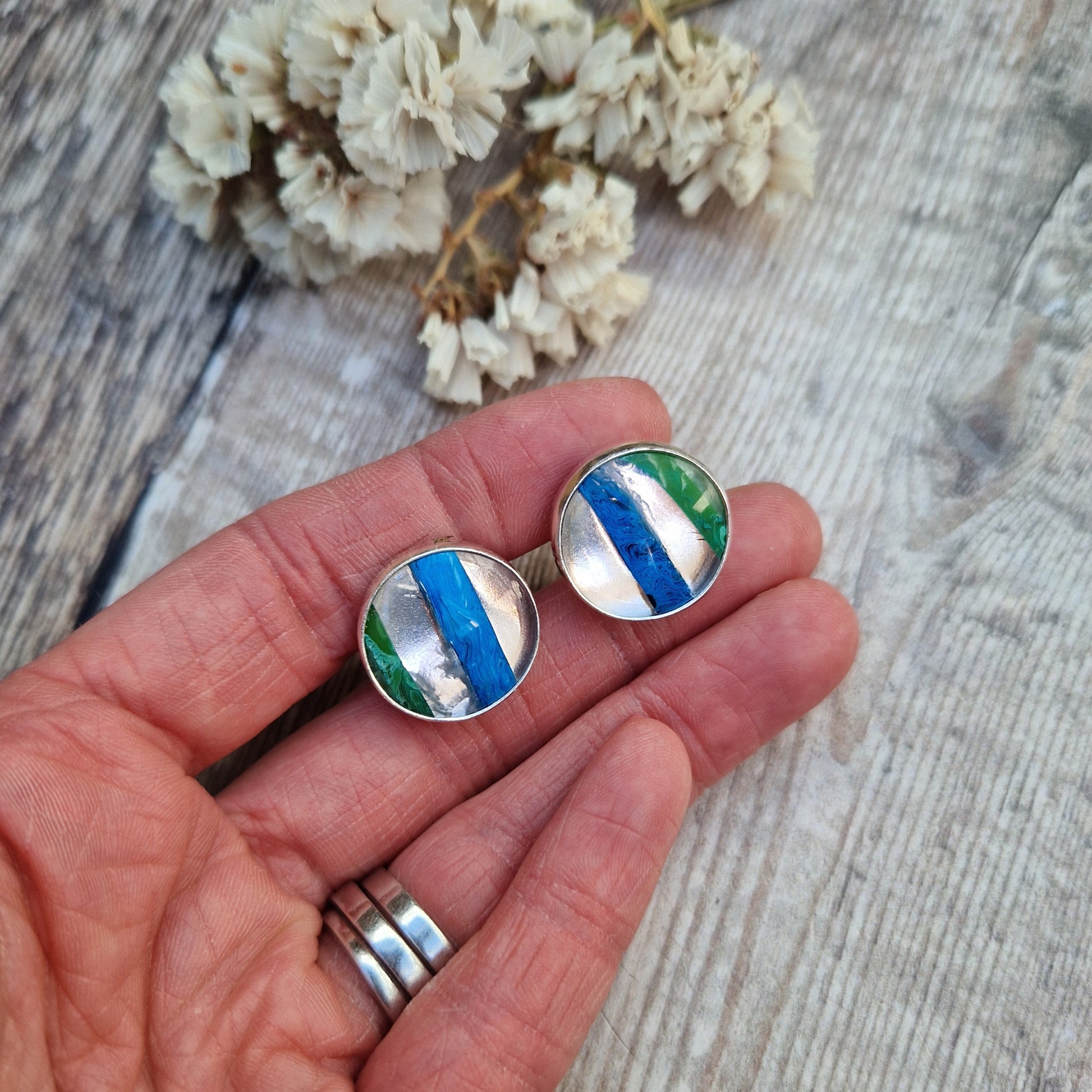 Sterling Silver round cufflinks approx. 18mm diameter each with surfite stone set in silver bezel surround. Horizonal, wide surfite stripes are green, clear, blue, clear and some black. Each surfite stone is individual.