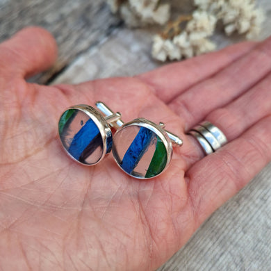 Sterling Silver round cufflinks approx. 18mm diameter each with surfite stone set in silver bezel surround. Horizonal, wide surfite stripes are green, clear, blue, clear and some black. Each surfite stone is individual.