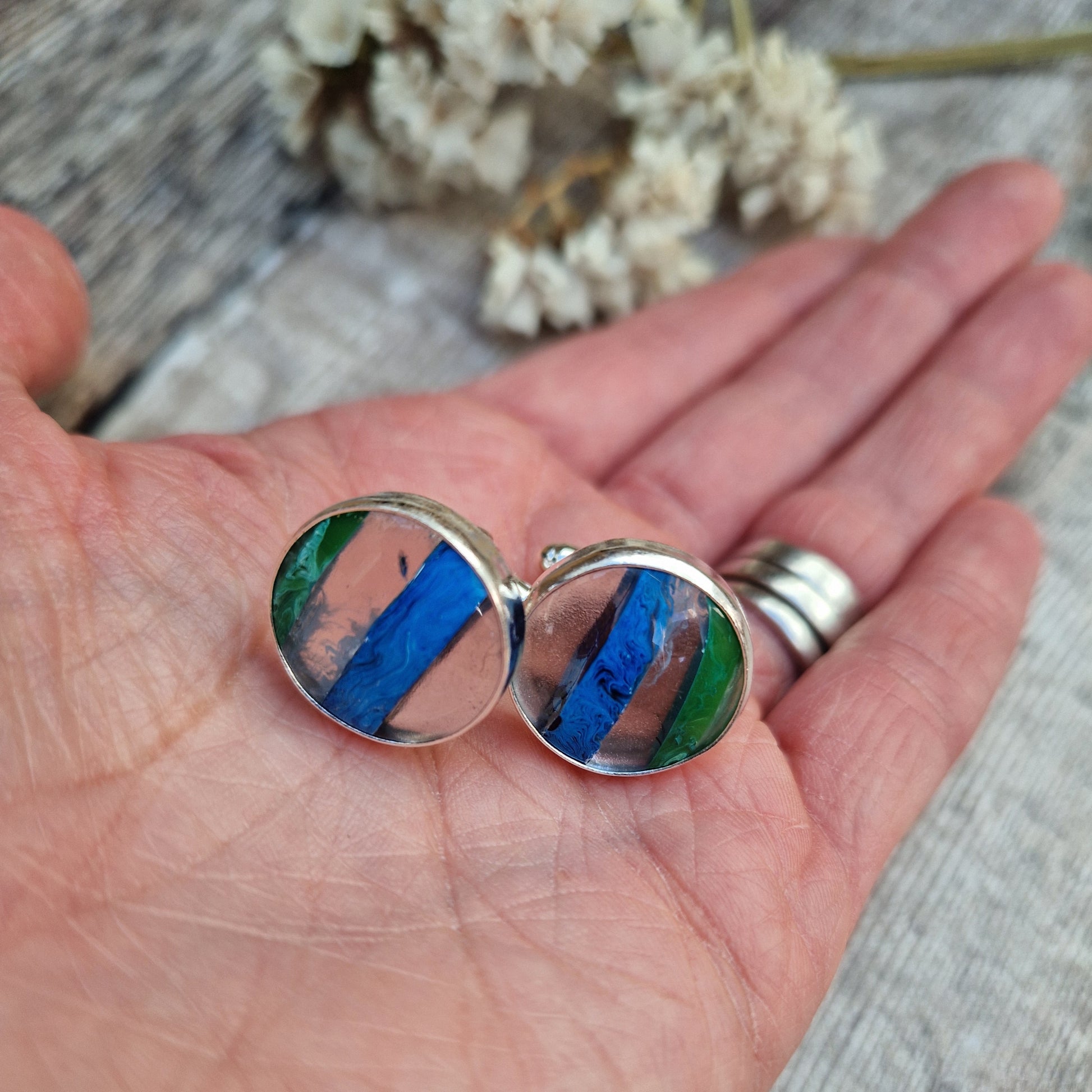 Sterling Silver round cufflinks approx. 18mm diameter each with surfite stone set in silver bezel surround. Horizonal, wide surfite stripes are green, clear, blue, clear and some black. Each surfite stone is individual.