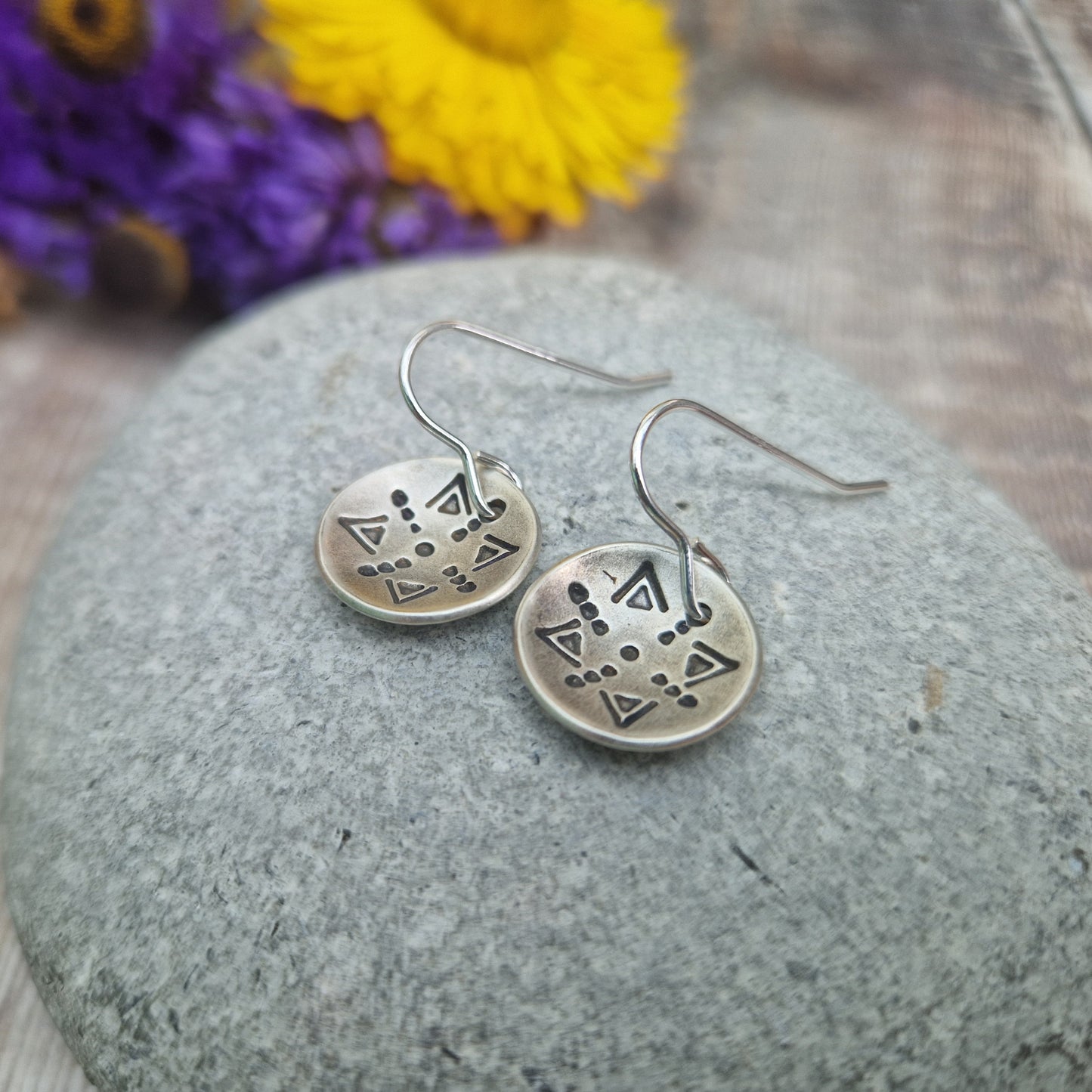 Oxidised Sterling Silver dome shaped pendant suspended from silver earring wire. Each earring pendant has geometric triangular and dot patterns on the inside of the curved dome.