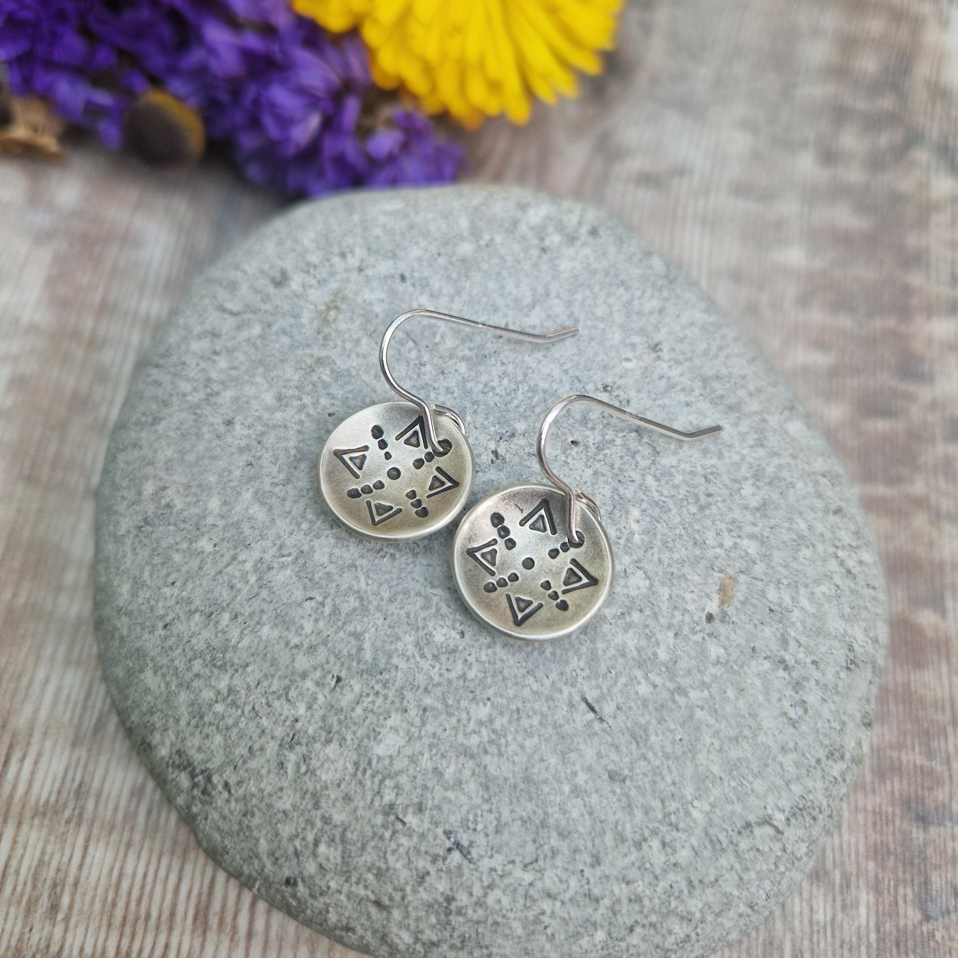 Oxidised Sterling Silver dome shaped pendant suspended from silver earring wire. Each earring pendant has geometric triangular and dot patterns on the inside of the curved dome.