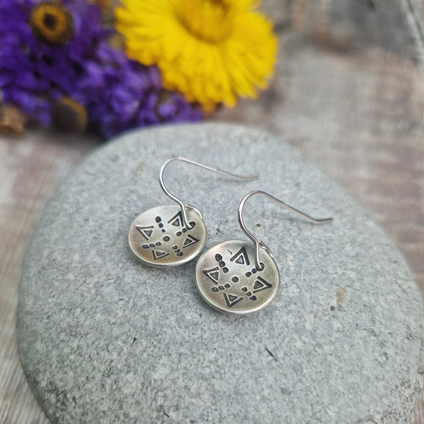 Oxidised Sterling Silver dome shaped pendant suspended from silver earring wire. Each earring pendant has geometric triangular and dot patterns on the inside of the curved dome.