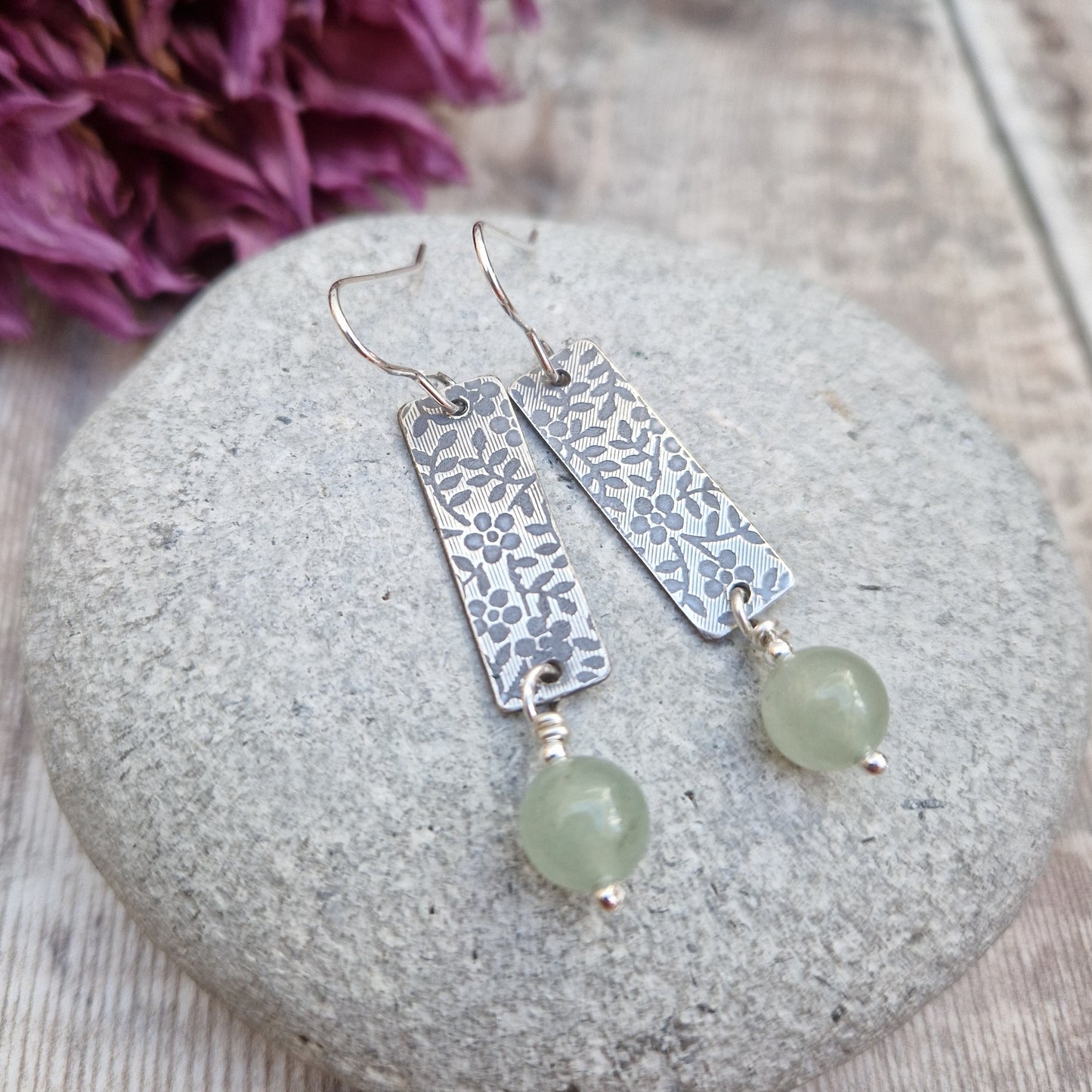 Each earring is a Sterling Silver rectangle stamped with a floral design suspended from earring wire. Suspended from the bottom of the rectangle is an Aventurine sphere gemstone, pale green/off white in colour.