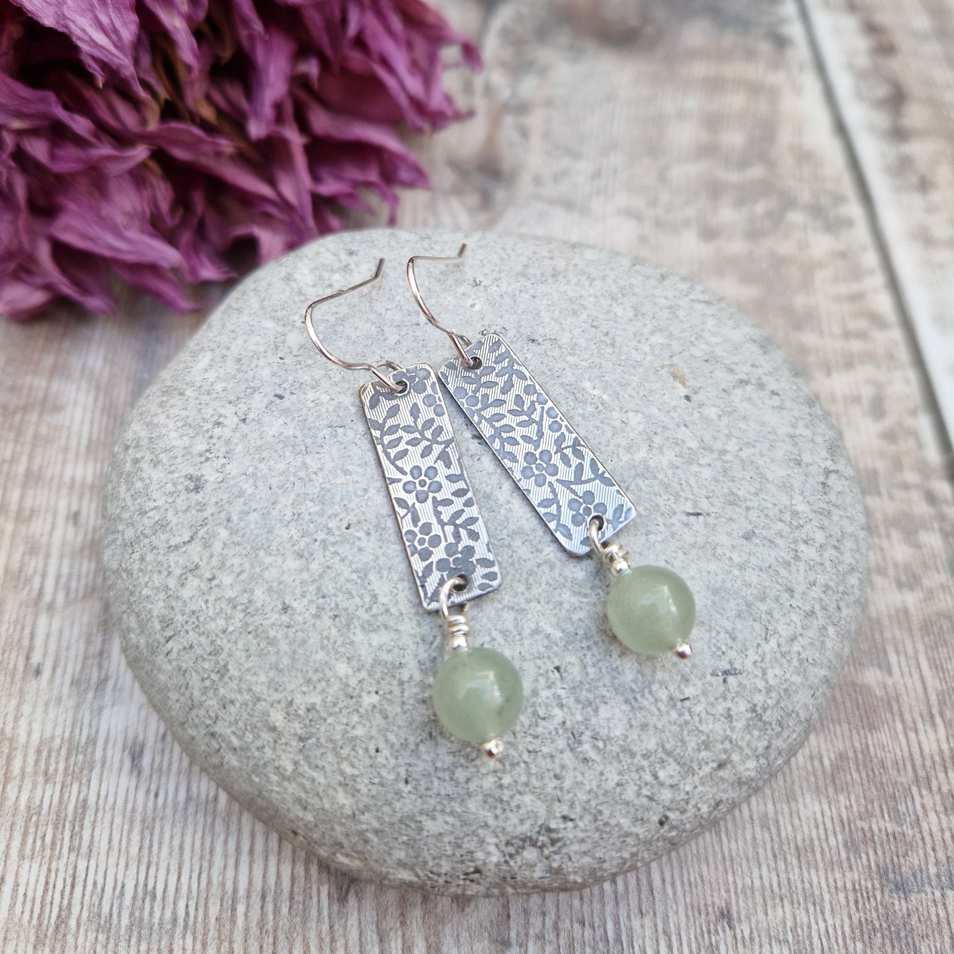 Each earring is a Sterling Silver rectangle stamped with a floral design suspended from earring wire. Suspended from the bottom of the rectangle is an Aventurine sphere gemstone, pale green/off white in colour.