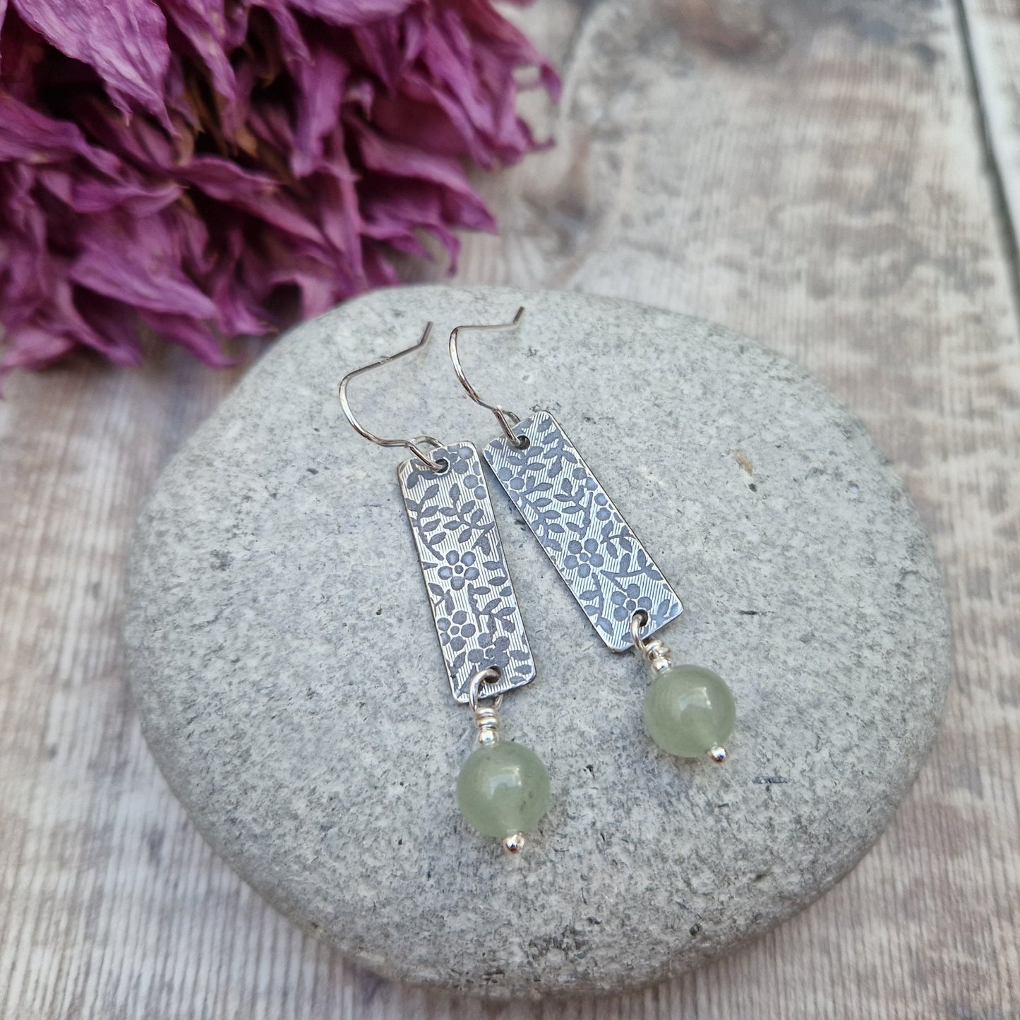 Each earring is a Sterling Silver rectangle stamped with a floral design suspended from earring wire. Suspended from the bottom of the rectangle is an Aventurine sphere gemstone, pale green/off white in colour.