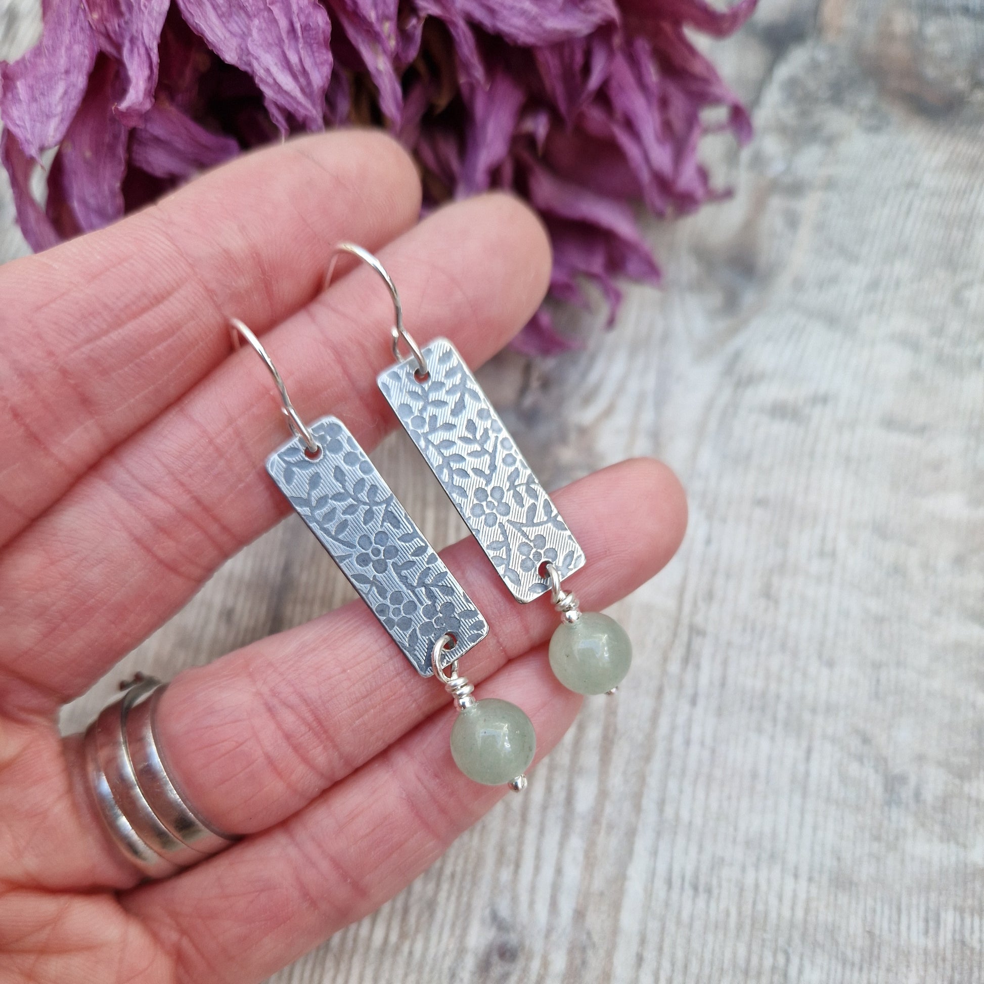 Each earring is a Sterling Silver rectangle stamped with a floral design suspended from earring wire. Suspended from the bottom of the rectangle is an Aventurine sphere gemstone, pale green/off white in colour.