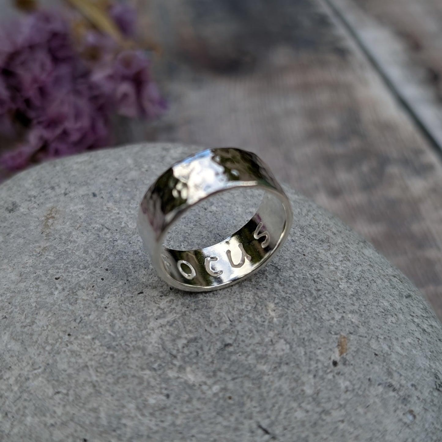 Sterling silver wide ring band with hammered texture finish and high polish. F O C U S stamped on the inside of the band.