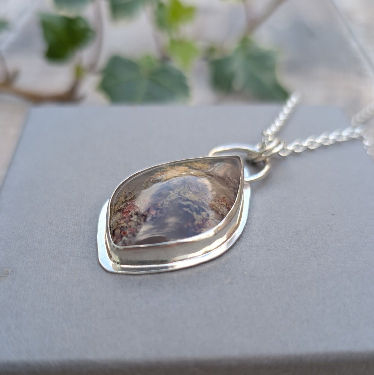 Detailed side view of Garden Moss Agate Statement Gemstone Necklace showing the raised sterling silver bezel setting, polished gemstone surface and natural inclusions within the stone.