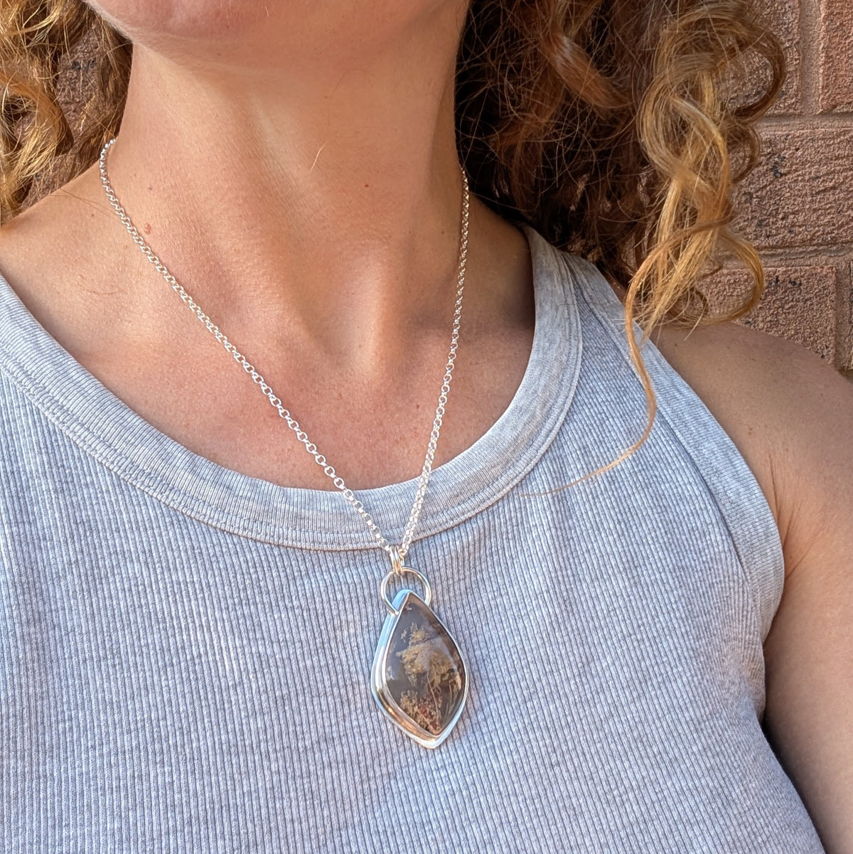Garden Moss Agate Statement Gemstone Necklace worn on a sterling silver chain over a grey vest top, showing the size and length of the handmade pendant.