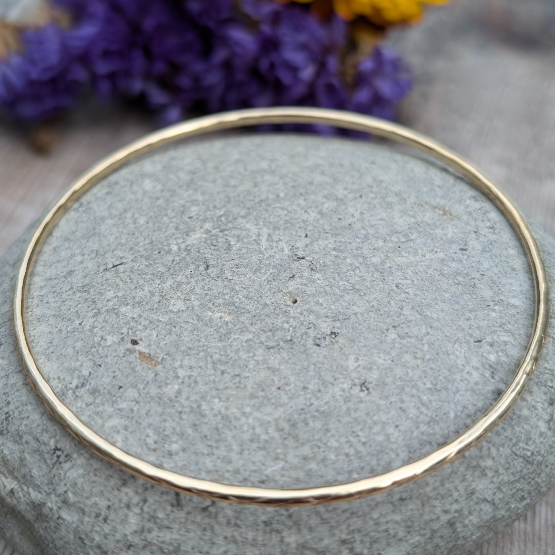 Slim gold bangle decorated with indented starlight pattern.