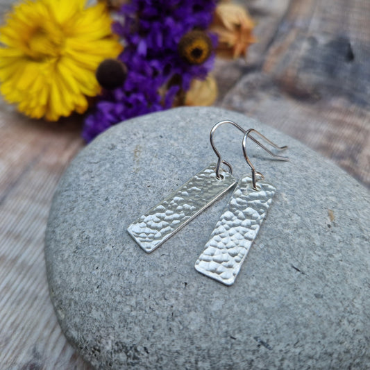 Each earring is a silver rectangle with hammered texture finish suspended from a silver earring wire.