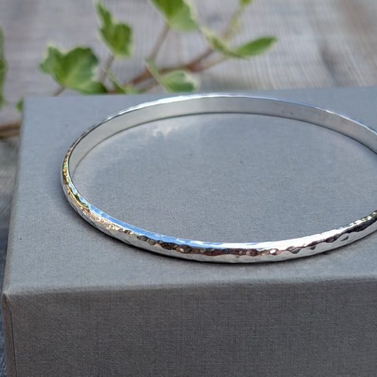 Close up of a Hammered Sterling Silver D Shape Bangle showing the hand hammered texture on recycled Sterling Silver D shaped wire.