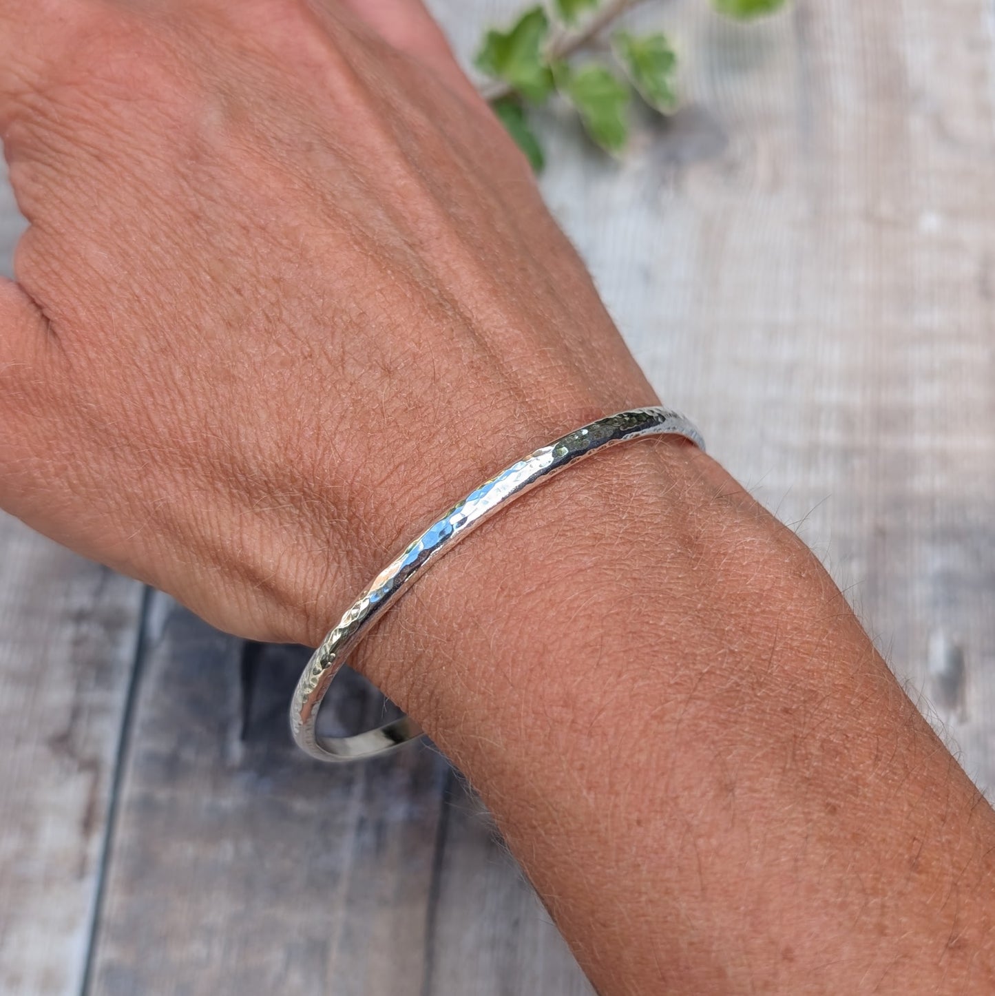 Hammered Sterling Silver D Shape Bangle handmade from recycled Sterling Silver D shaped wire being worn on the wrist to show fit and size.
