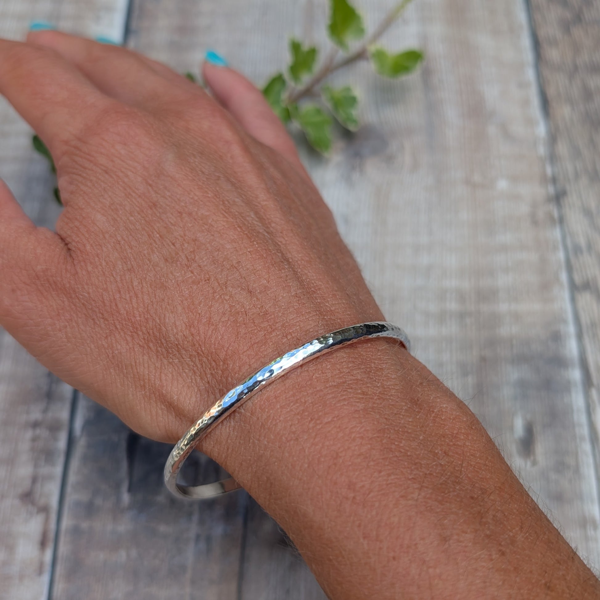 Hammered Sterling Silver D Shape Bangle handmade from recycled Sterling Silver D shaped wire worn on the wrist with a polished hammered finish.