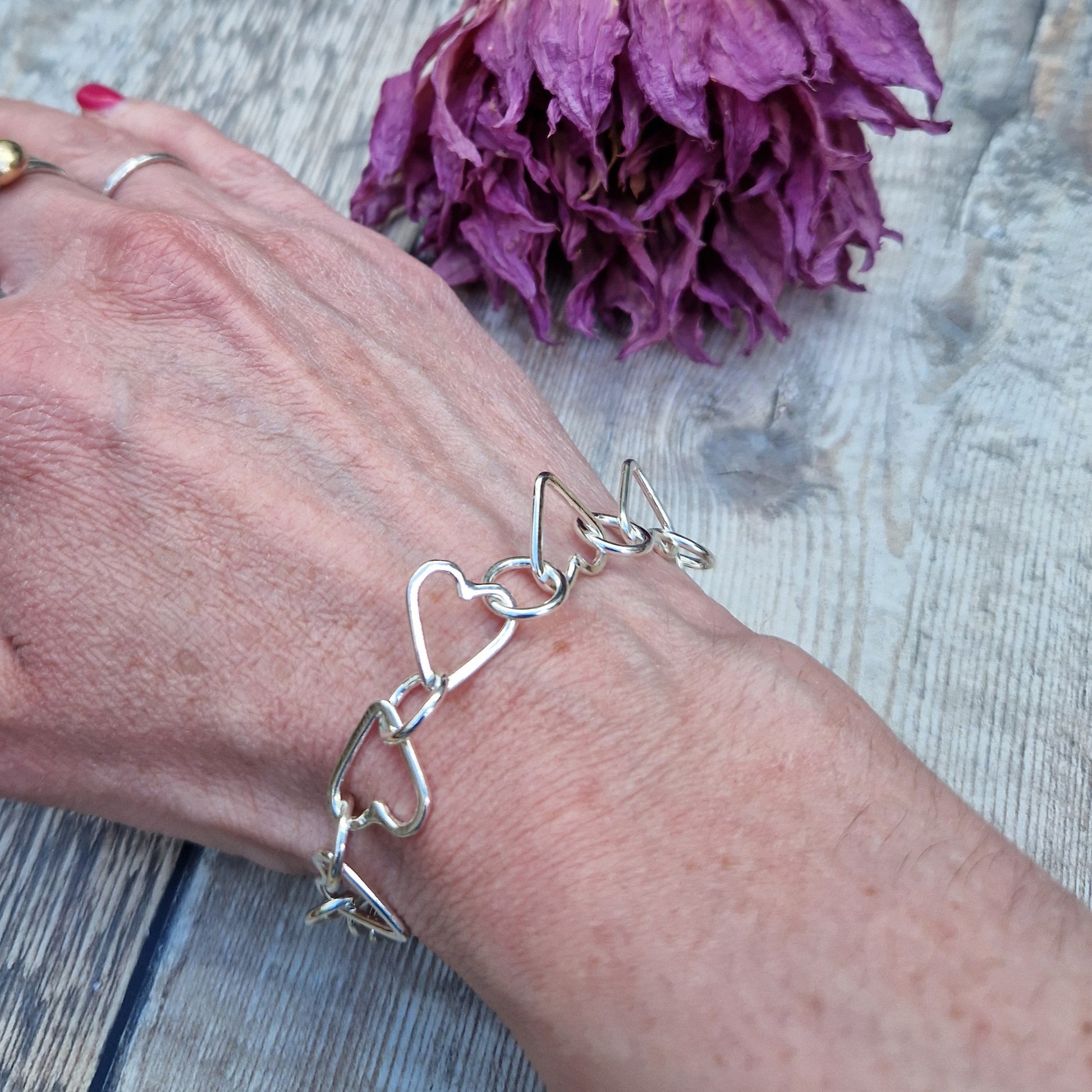 Sterling Silver interlinking hearts bracelet. Each open heart is linked with an open circle, nine hearts and 10 circles in total repeating pattern with ‘S’ link.