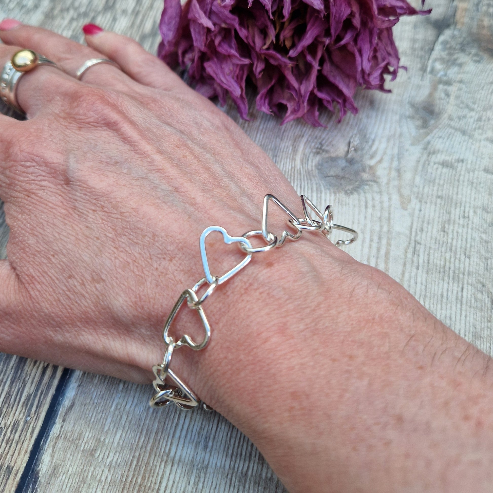 Sterling Silver interlinking hearts bracelet. Each open heart is linked with an open circle, nine hearts and 10 circles in total repeating pattern with ‘S’ link.