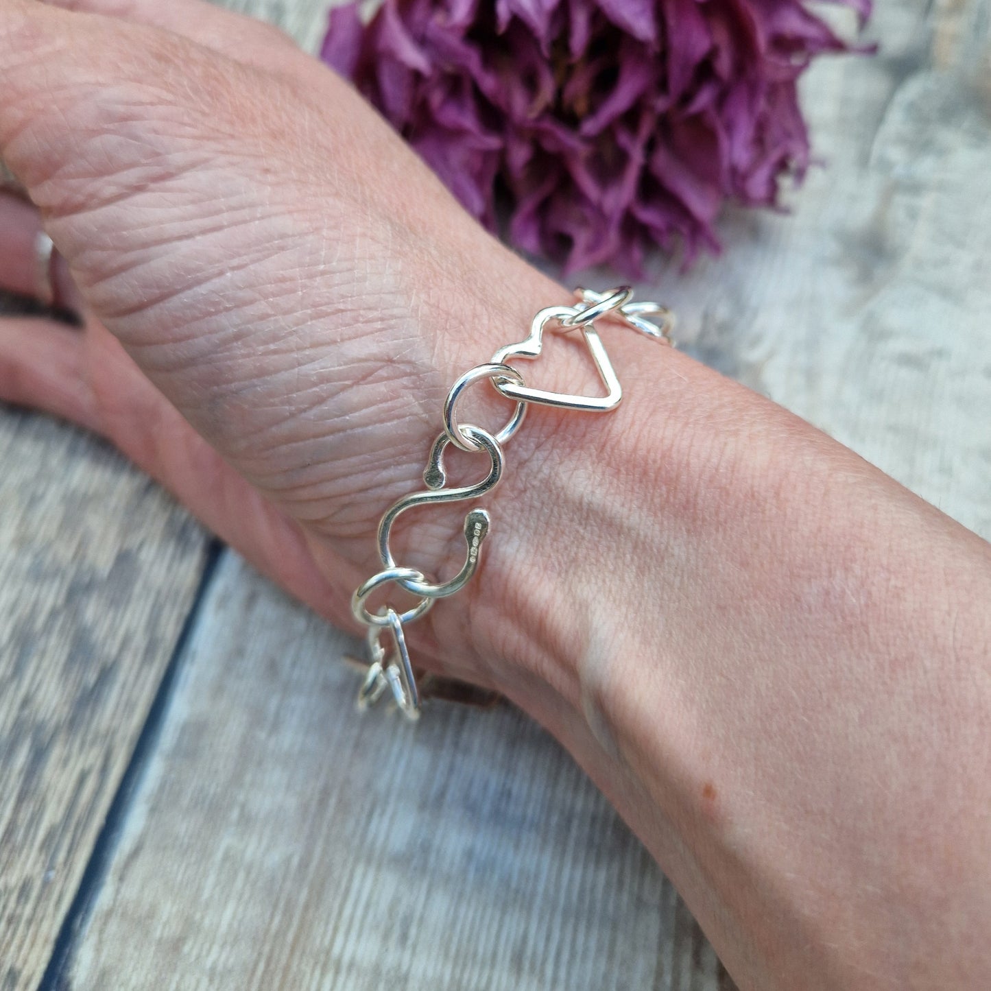 Sterling Silver interlinking hearts bracelet. Each open heart is linked with an open circle, nine hearts and 10 circles in total repeating pattern with ‘S’ link.