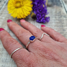 Load image into Gallery viewer, Sterling Silver Lapis Lazuli Blue Gemstone Ring, UK Size R. Royal blue coloured stone, oval shape with slight diamond hammered texture, set in a delicate scalloped edge silver surround, placed lengthwise on top of ring. Stone measures approximately 6mm x 8 mm. Ring band is approx. 2 mm wide.