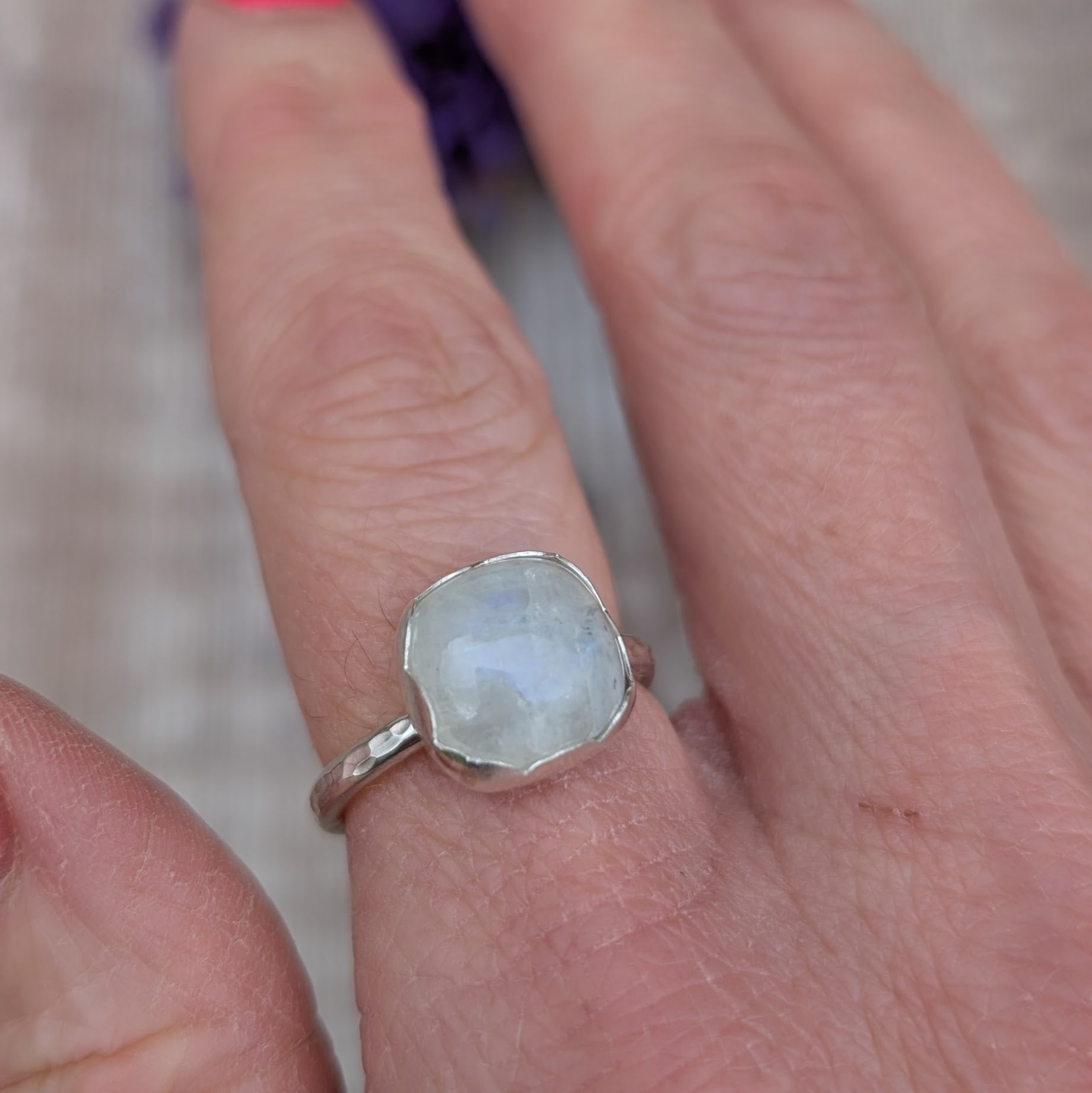 Close-up of a Silver Moonstone Ring on a finger, highlighting the natural look of the moonstone and handmade silver setting.