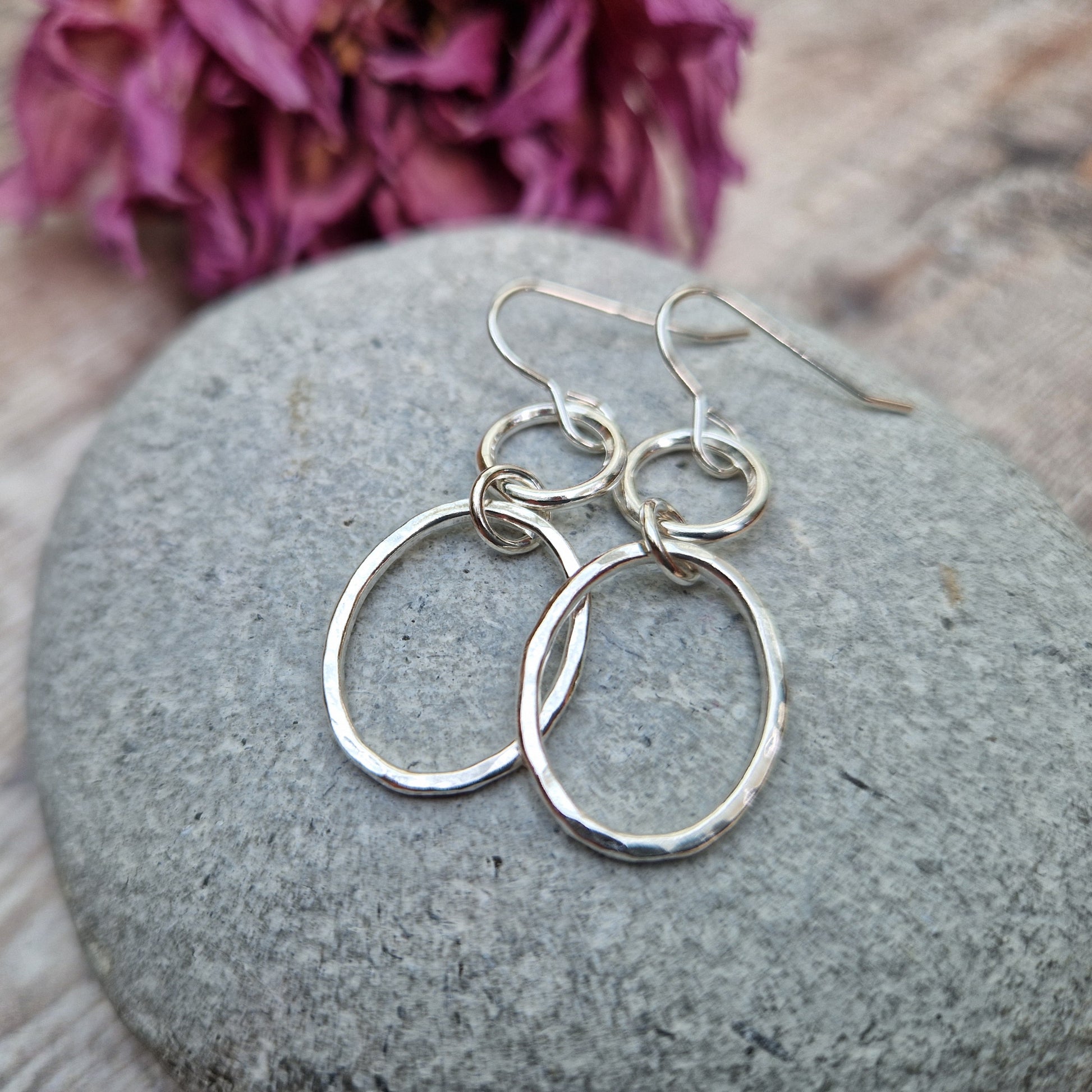 Each earring has one Sterling Silver open circle suspended from silver earring wire. A hammered texture silver open oval hangs from the open circle via a small circle link. 