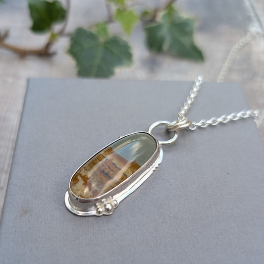 Close-up of Owyhee Picture Jasper Statement Gemstone Necklace showing the polished green, brown and cream gemstone set in Sterling Silver with small silver ball details.