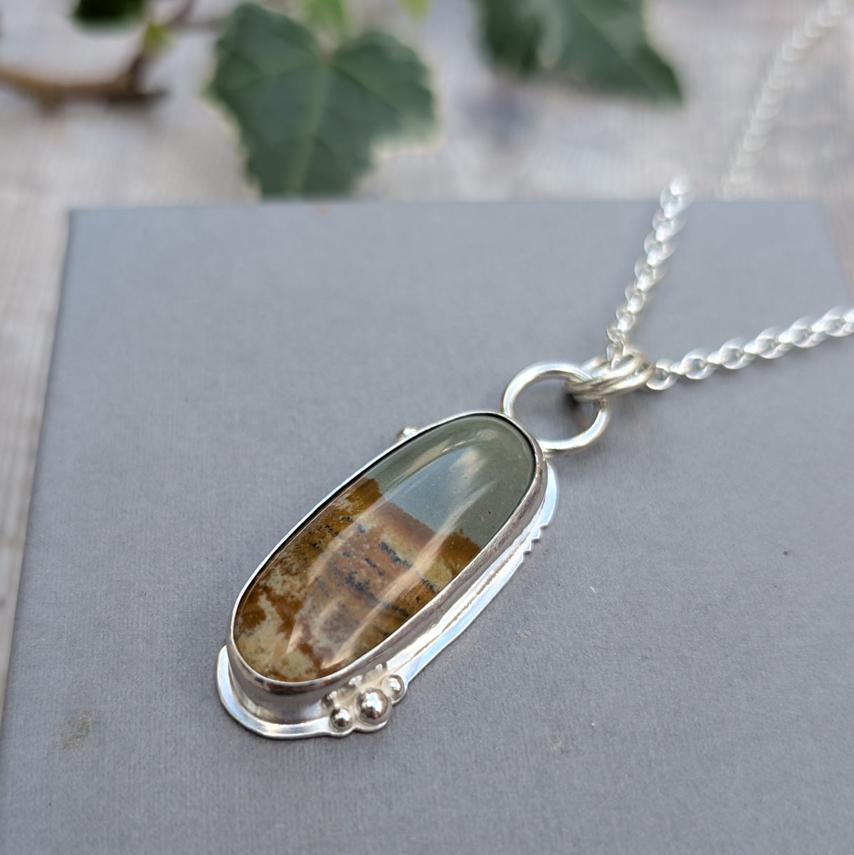 Detailed view of Owyhee Picture Jasper Statement Gemstone Necklace showing the natural colours and patterns of the gemstone, silver bezel setting and decorative silver balls