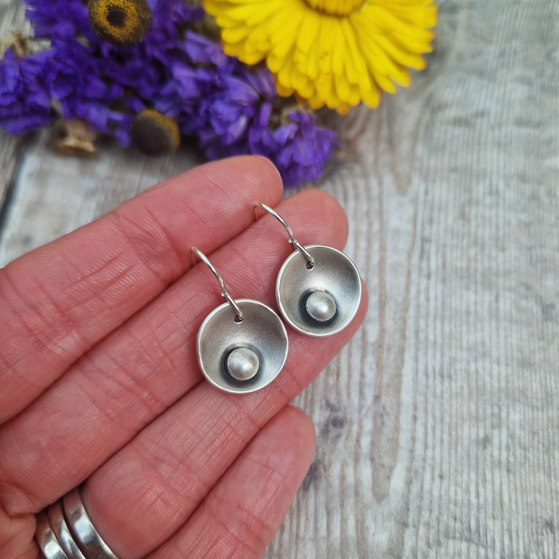 Oxidised Sterling Silver domed disc suspended from silver earring wire with oxidised silver pebble attached to the inside of the dome.