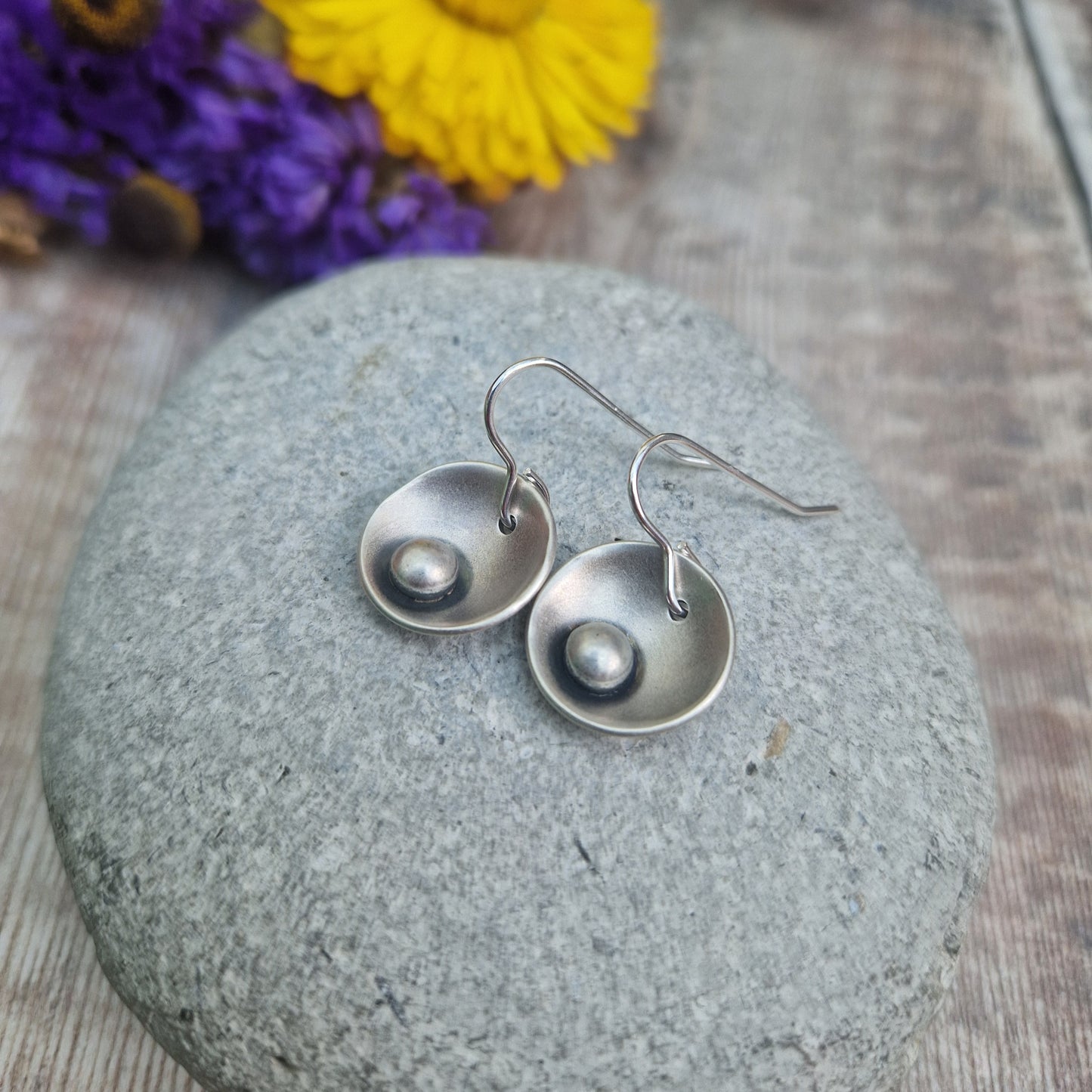 Oxidised Sterling Silver domed disc suspended from silver earring wire with oxidised silver pebble attached to the inside of the dome.