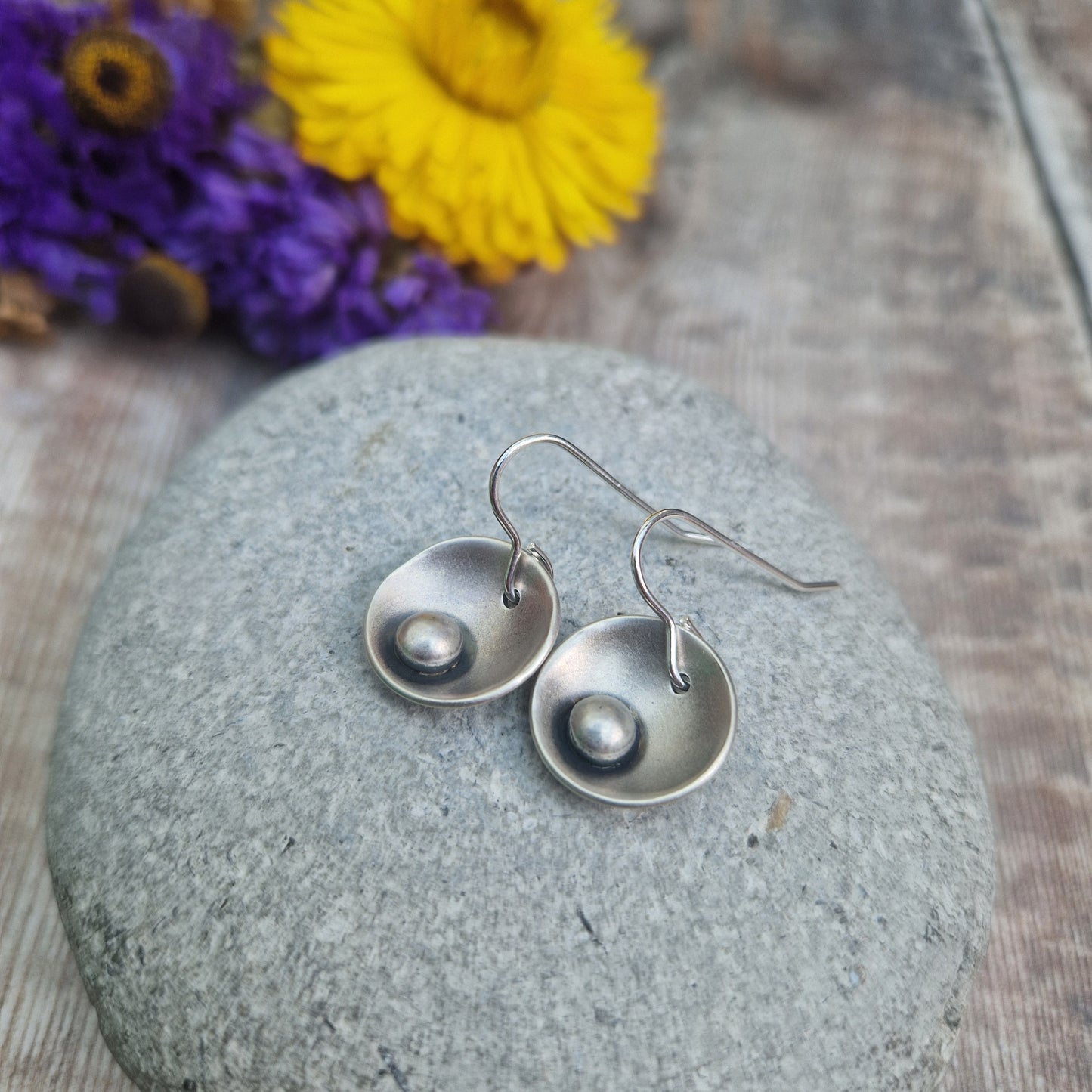 Oxidised Sterling Silver domed disc suspended from silver earring wire with oxidised silver pebble attached to the inside of the dome.