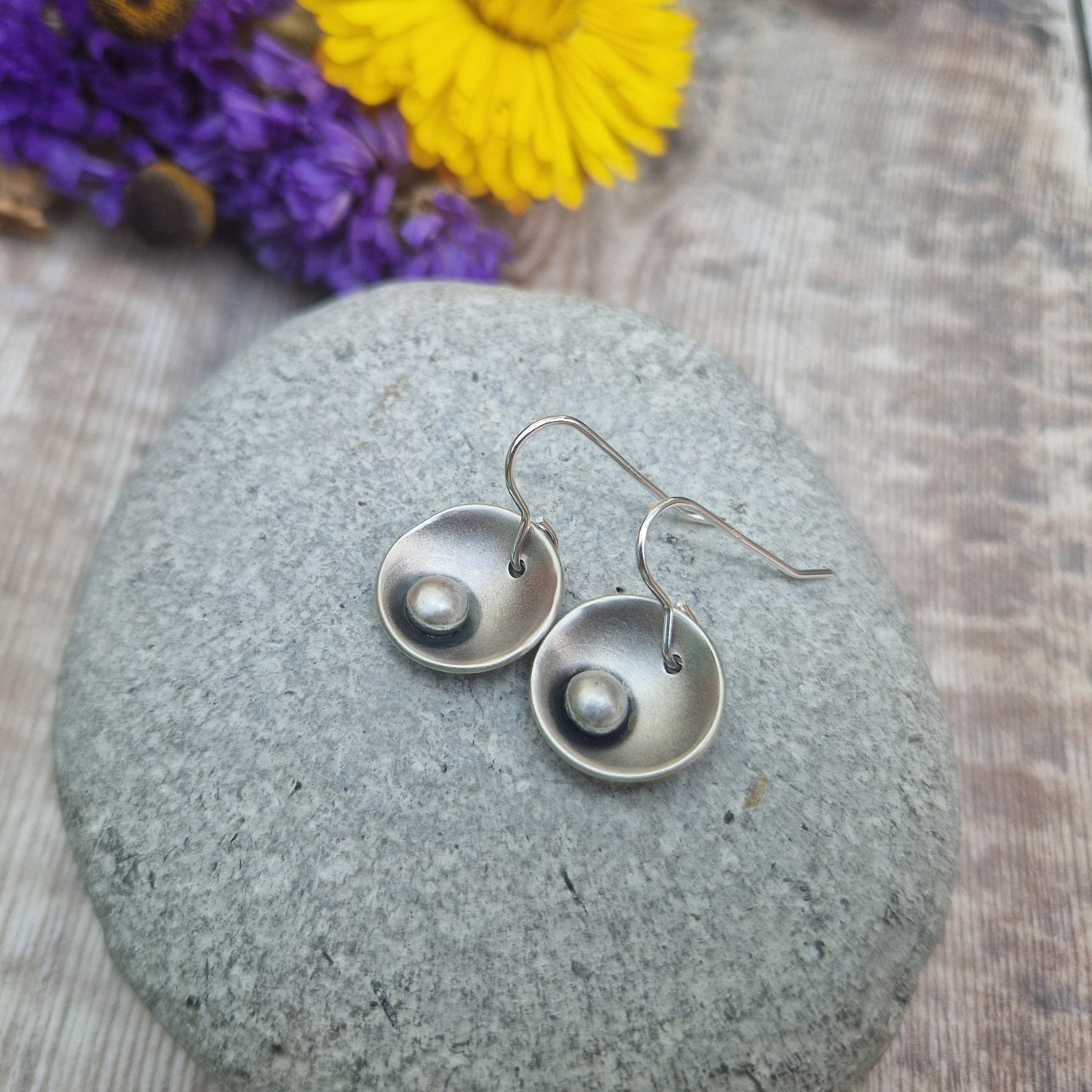 Oxidised Sterling Silver domed disc suspended from silver earring wire with oxidised silver pebble attached to the inside of the dome.