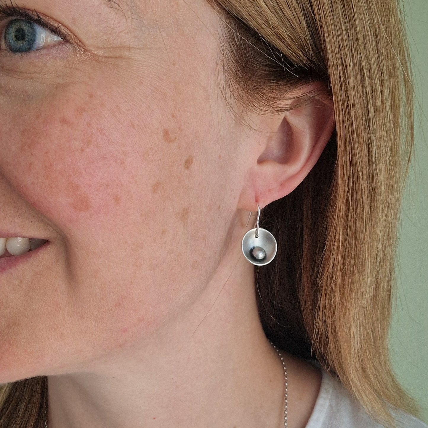 Oxidised Sterling Silver domed disc suspended from silver earring wire with oxidised silver pebble attached to the inside of the dome.