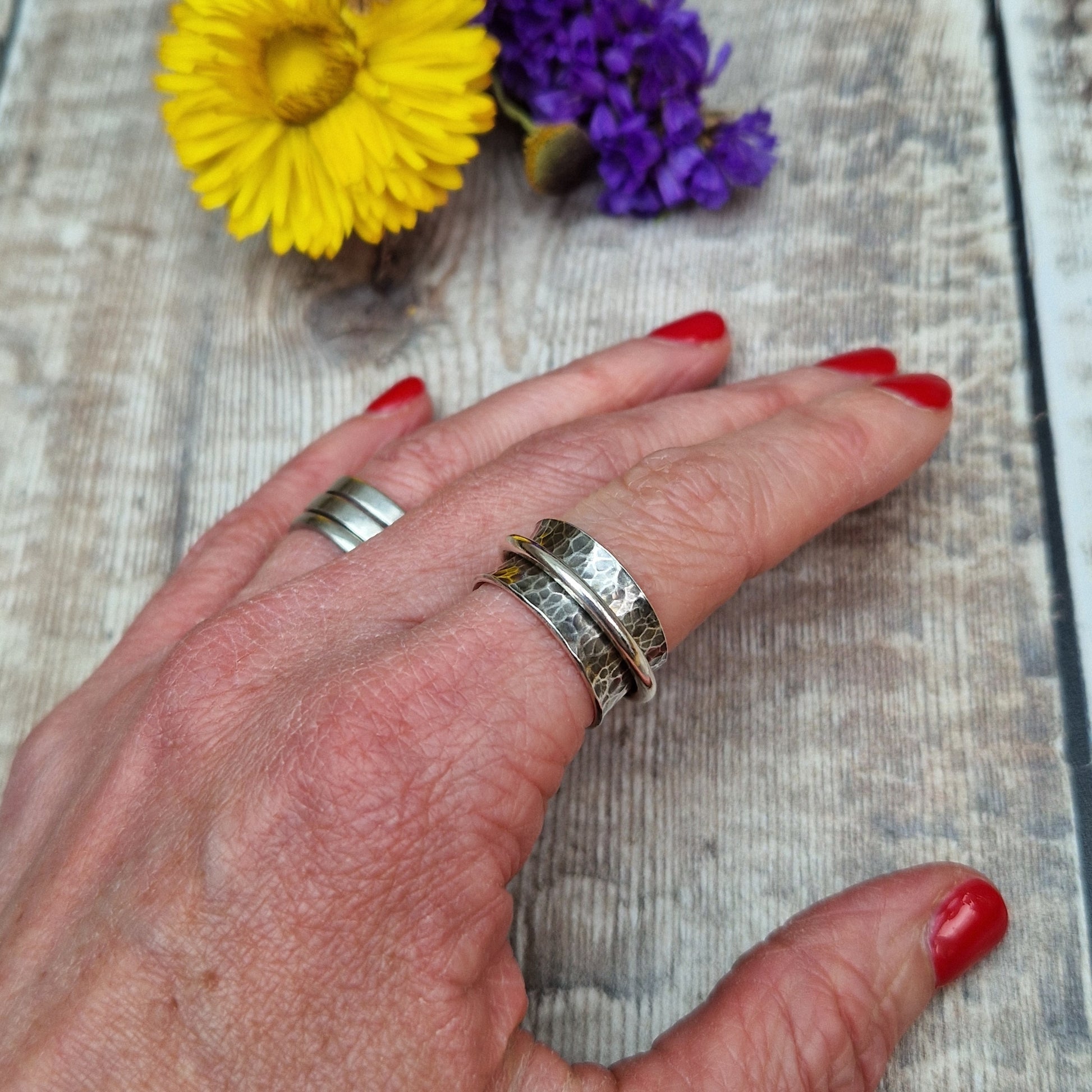 Wide oxidised Sterling Silver band with hammered texture finish with additional 2mm wide silver band around the middle that spins independently.