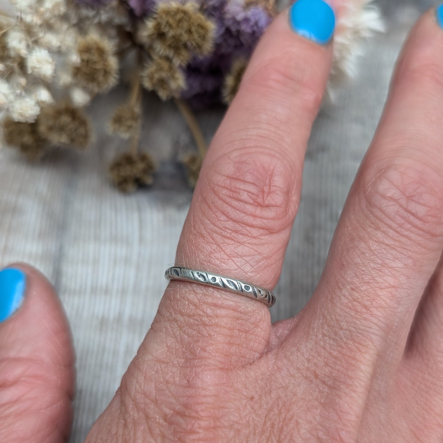 Oxidised Sterling silver band approx. 2mm diameter stamped with dot and leaf pattern. 