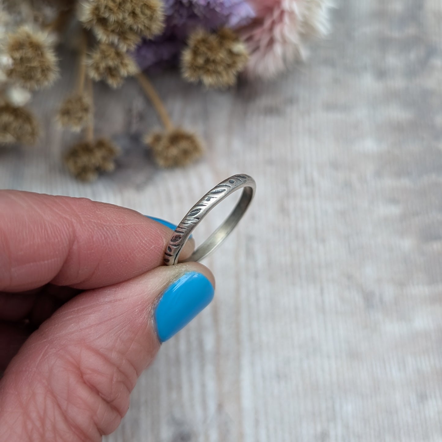 Oxidised Sterling silver band approx. 2mm diameter stamped with dot and leaf pattern. 