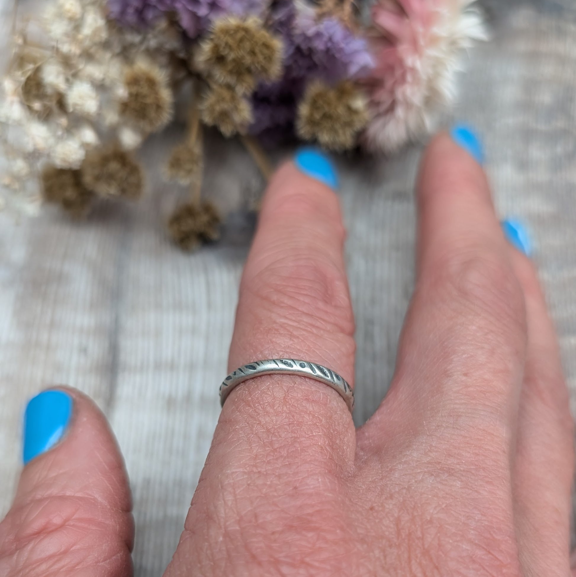 Oxidised Sterling silver band approx. 2mm diameter stamped with dot and leaf pattern. 