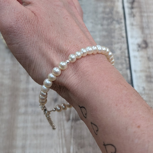 Freshwater pearl bracelet with a sterling silver clasp and extender chain, shown worn on the wrist.