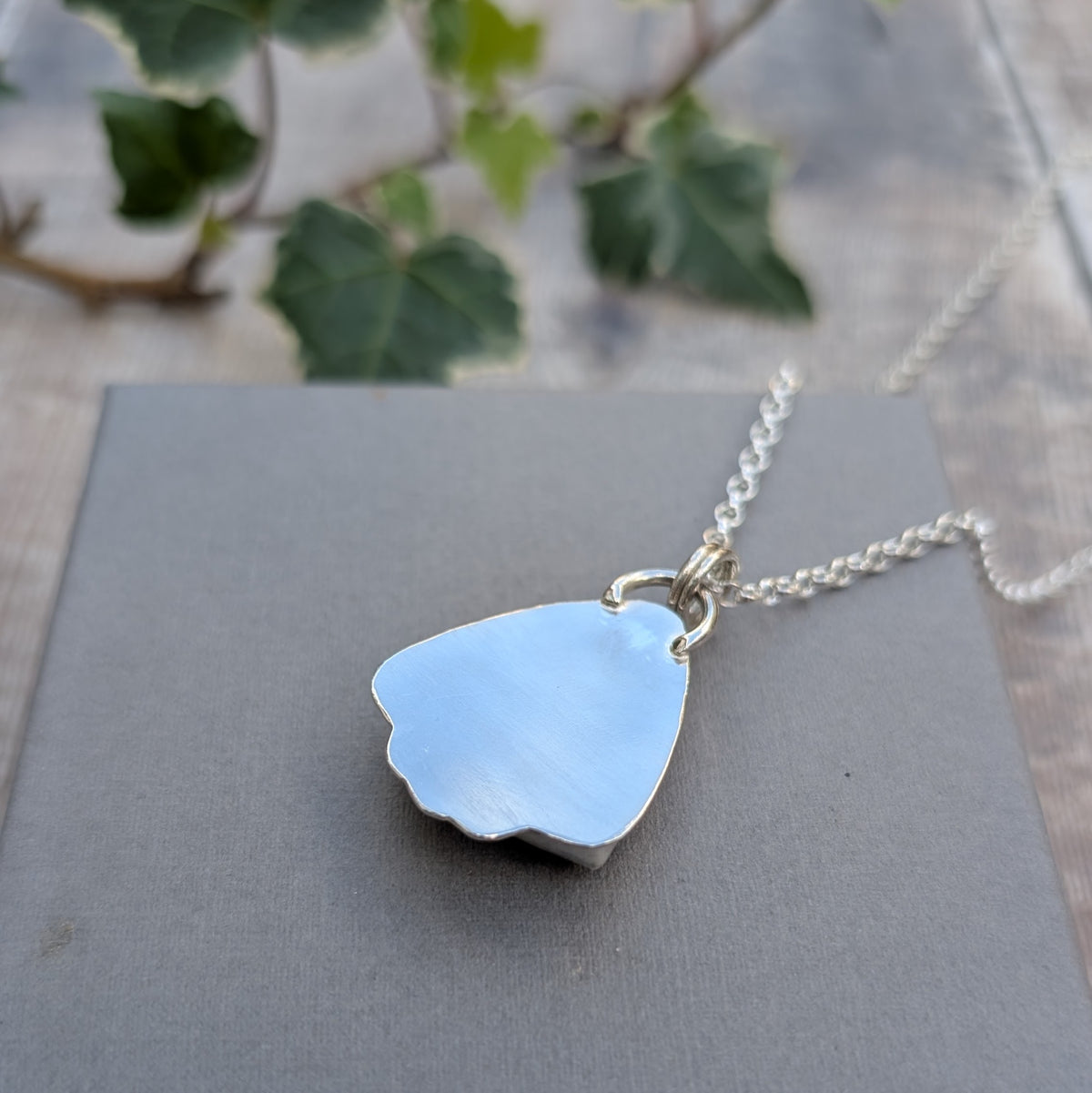 Back view of the Petrified Palm Wood Statement Gemstone Necklace, showing the smooth recycled sterling silver backing, handmade pendant shape and silver chain.
